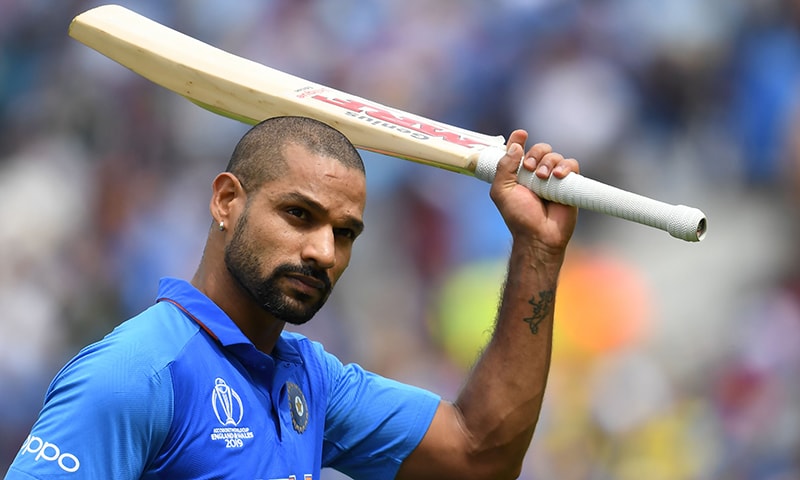 India's Shikhar Dhawan raises his bat to the crowd as he walks back to the pavilion after his dismissal during the 2019 Cricket World Cup group stage match between India and Australia. — AFP