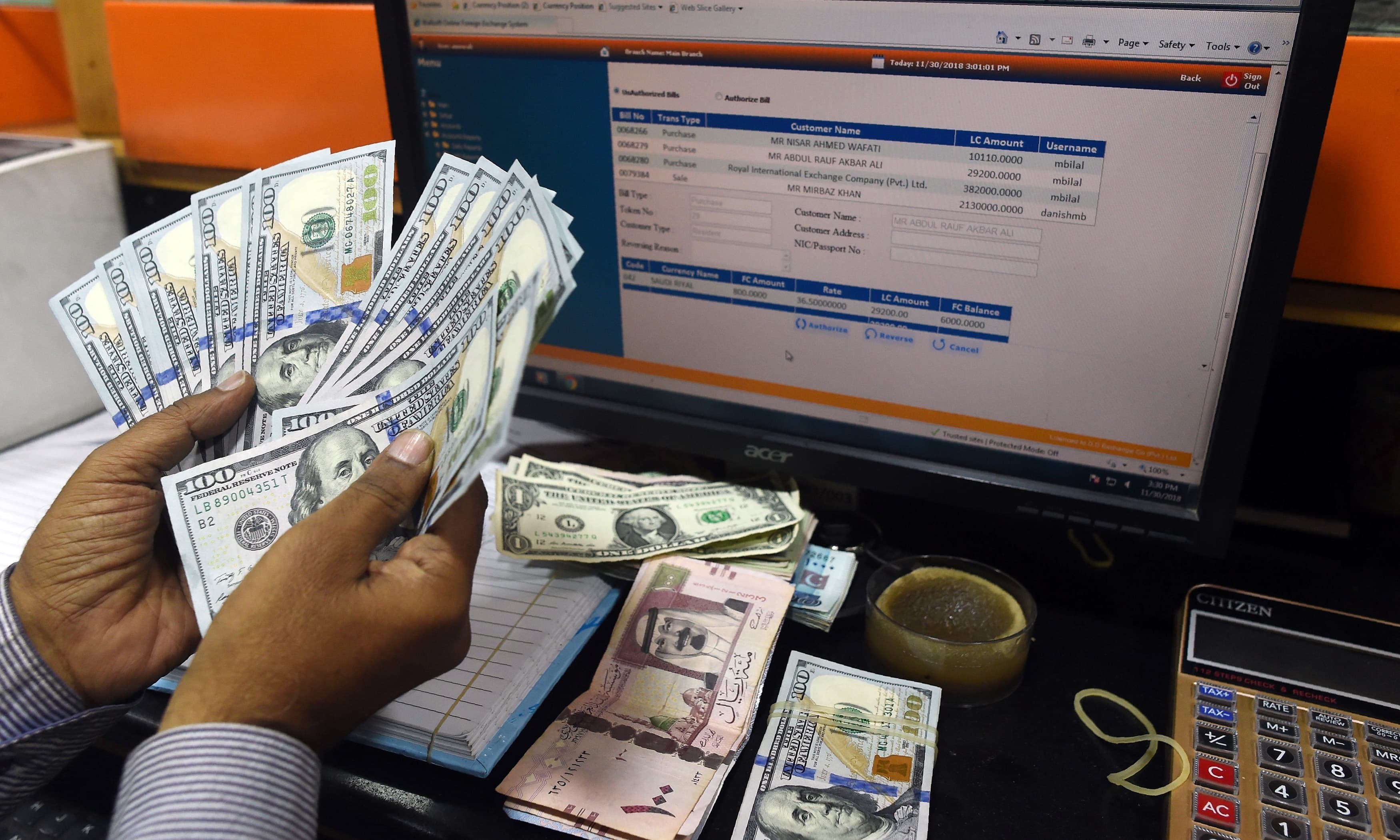 A Pakistani dealer counts US dollars at a currency exchange shop in Karachi on November 30, 2018. — AFP/File