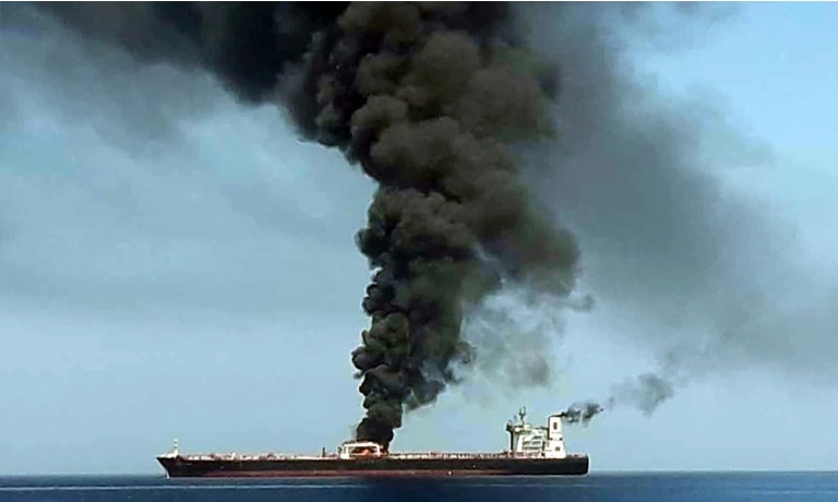 A picture from Iranian State TV IRIB on June 13 reportedly shows smoke billowing from a tanker said to have been attacked off the coast of Oman. — AFP