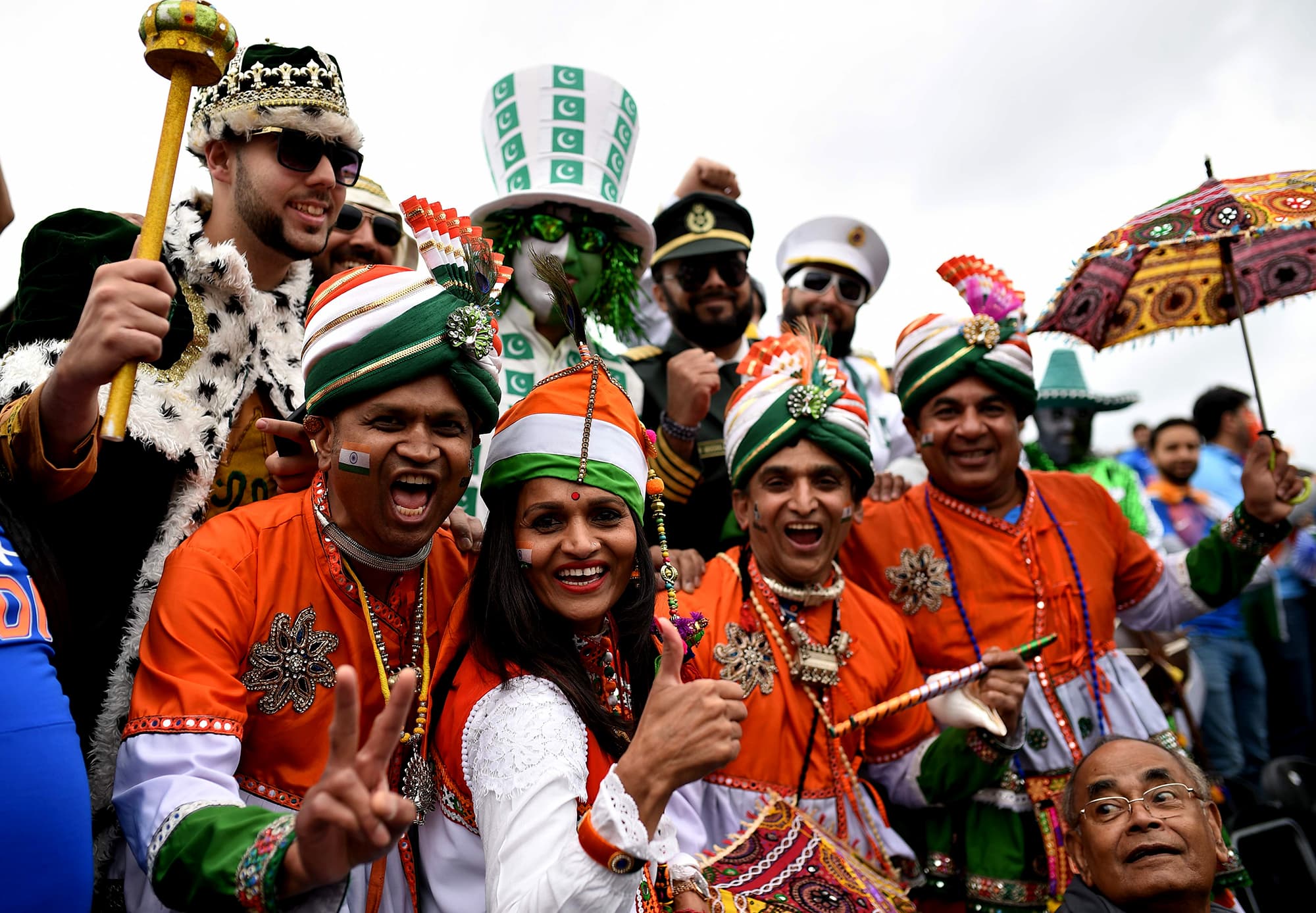 Indian fans in costume jump into the frame with Pakistani fans in costume. ─ AFP