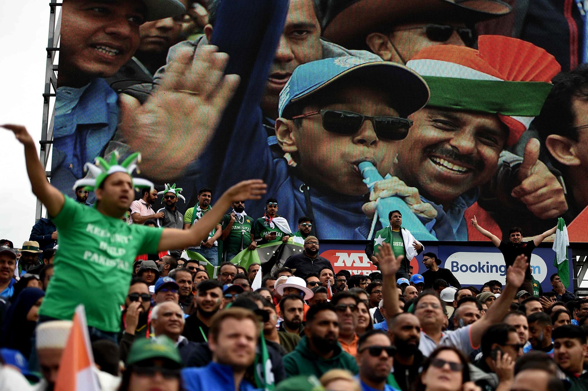 Indian and Pakistani supporters cheer on their teams during the match. ─ AFP