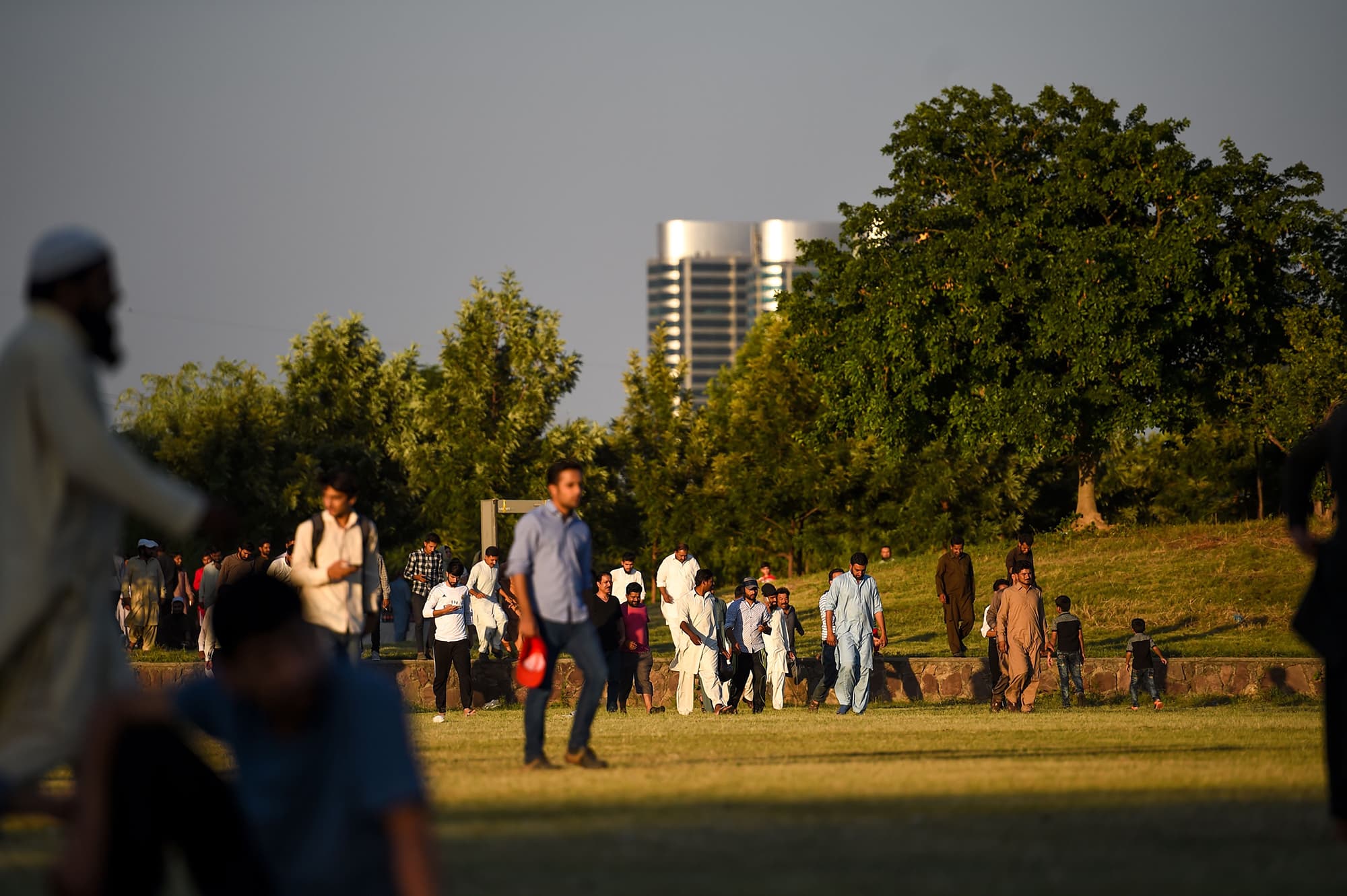 Pakistani people arrive at a park to watch a live broadcast of the match between Pakistan and India on a big screen in Islamabad. ─ AFP