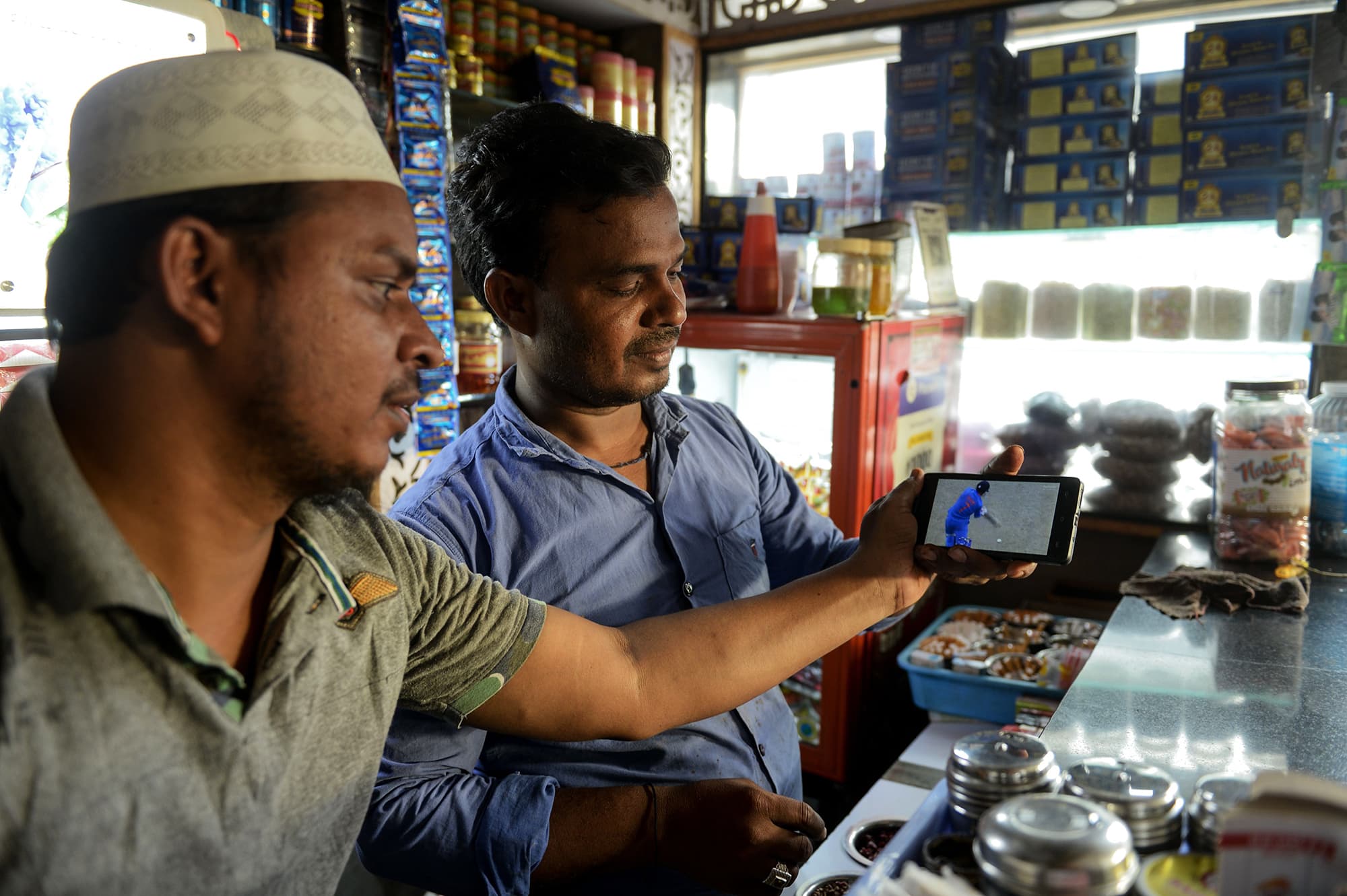 Indian fans watch a live broadcast of the match on a mobile phone at a paan shop in Hyderabad. ─ AFP