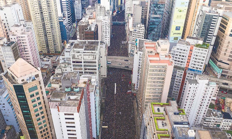 Hong Kong: This overhead view shows thousands of protesters marching through a street to protest the extradition law proposal. — AFP