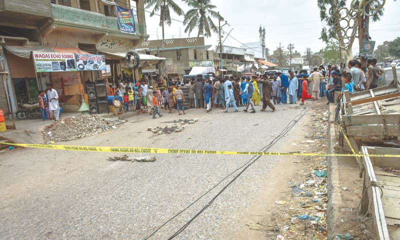 A CROWD gathers at the crime scene in Orangi on Monday.—Fahim Siddiqi / White Star