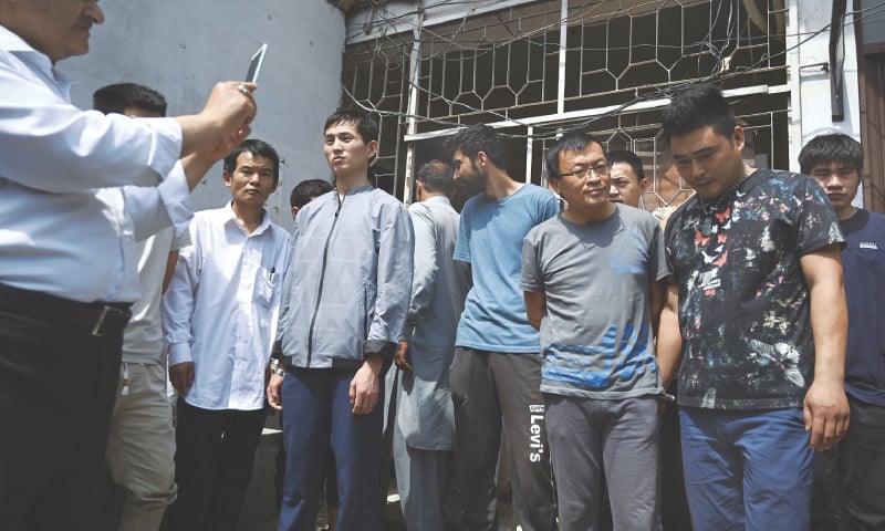 File photo of detained Chinese nationals outside a court in Islamabad.—AP