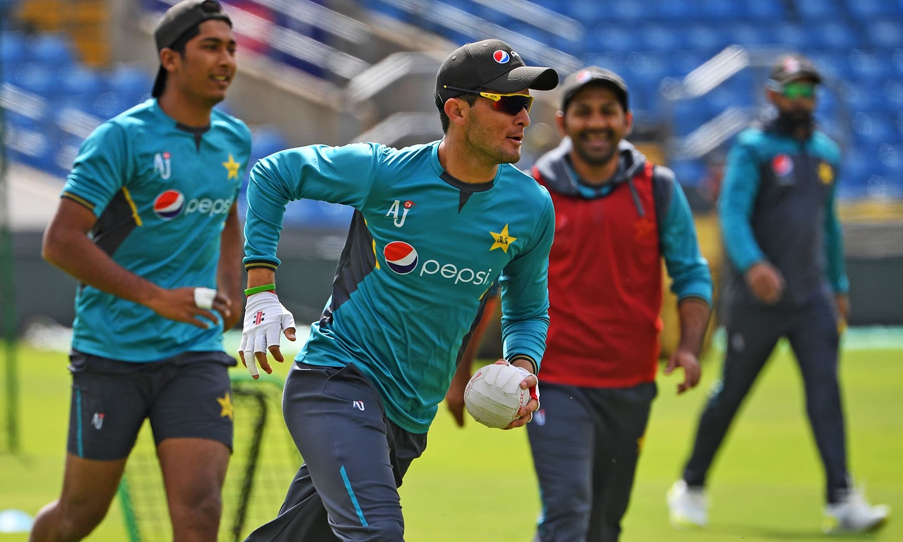 Shaheen Shah Afridi runs with the ball as skipper Sarfaraz looks on. — AFP