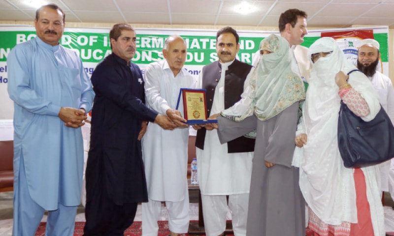 BISE Swat chairman giving away shield and gold medal to Kiran Khalil, who topped in the SSC annual examination. &mdash; Dawn