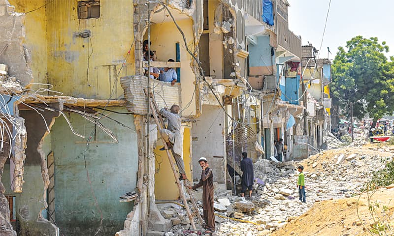 KARACHI: Residents of Mujahid Colony look at the damage done to their homes in May.—Fahim Siddiqi/White Star KARACHI: Residents of Mujahid Colony look at the damage done to their homes in May.—Fahim Siddiqi/White Star