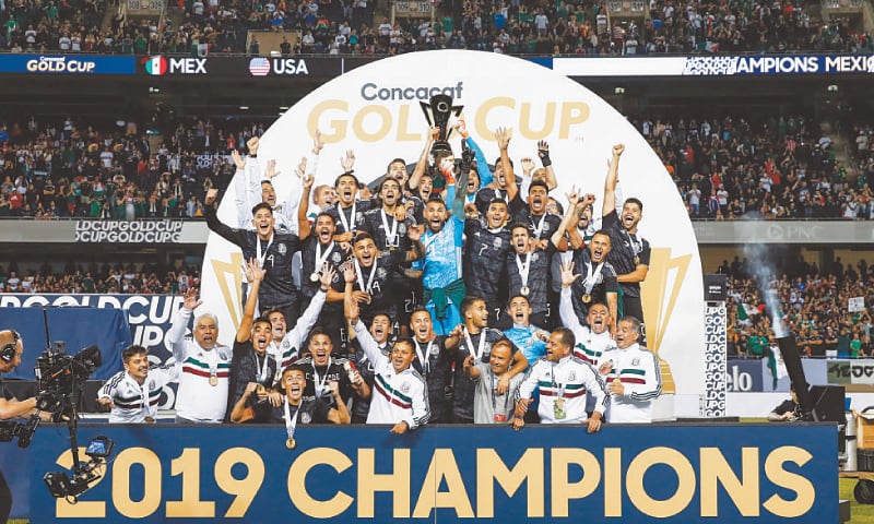 CHICAGO: Mexico players and coaches celebrate with the  trophy after beating the United States in the CONCACAF Gold Cup final at the Soldier Field Stadium.&mdash;AFP