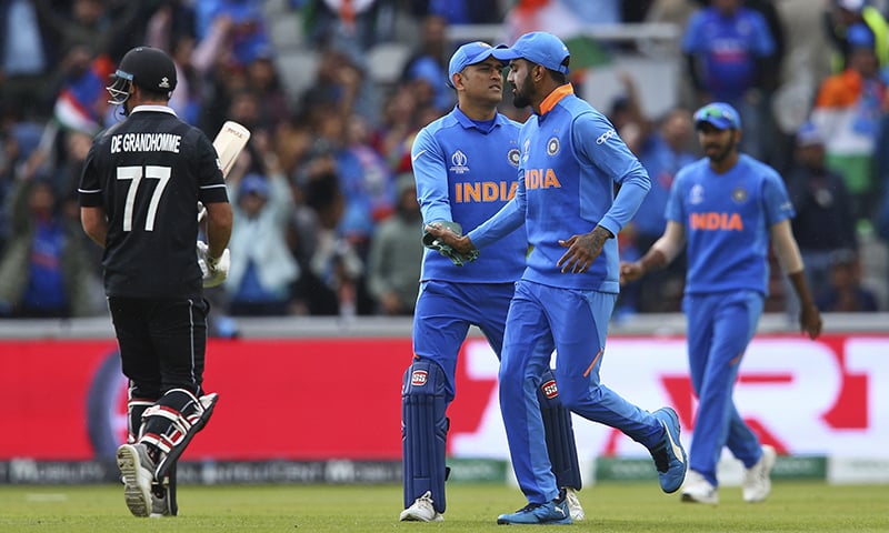 India's Mahendra Singh Dhoni, second left, celebrates after taking a catch to dismiss New Zealand's Colin de Grandhomme during the Cricket World Cup semifinal match between India and New Zealand at Old Trafford on July 9. — AP