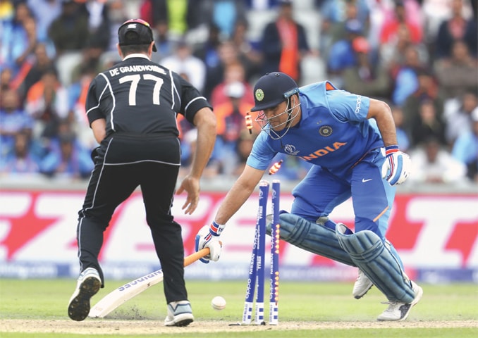 IN what proved to be the turning point of the game, Indian batsman M.S. Dhoni gets run out, as New Zealand’s Colin de Grandhomme looks on, during the first semi-final at Old Trafford on Wednesday.—AP