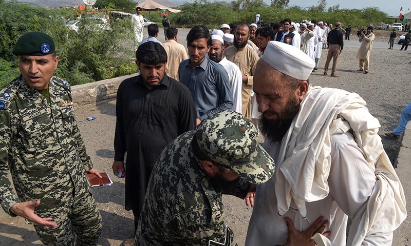 A security personnel searches tribesmen as they line up outside a polling station for the first provincial elections in Jamrud. ─ AFP