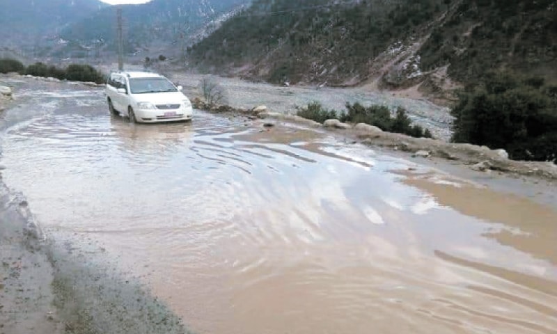 A vehicle passes through inundated Dir-Sheringal Road. &mdash; Dawn