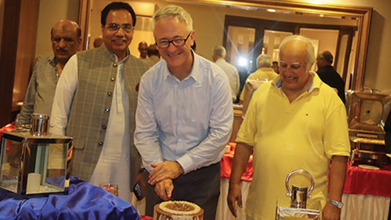 Head of the political section at the American embassy Ted Craig cuts a cake at a farewell hosted by former senator Enver Baig.