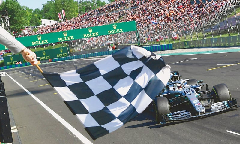 BUDAPEST: Mercedes’ British driver Lewis Hamilton takes the checkered flag to win the Hungarian F1 Grand Prix at the Hungaroring circuit on Sunday.—AFP BUDAPEST: Mercedes’ British driver Lewis Hamilton takes the checkered flag to win the Hungarian F1 Grand Prix at the Hungaroring circuit on Sunday.—AFP