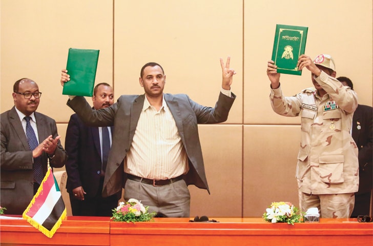 Khartoum: (Left to right) Ethiopian mediator Mahmoud Drir, protest leader Ahmad Rabie, and General Mohamed Hamdan Daglo, Sudan&rsquo;s deputy head of the Transitional Military Council, celebrate after signing the constitutional declaration, at a ceremony attended by African Union and Ethiopian mediators on Sunday.&mdash;AFP