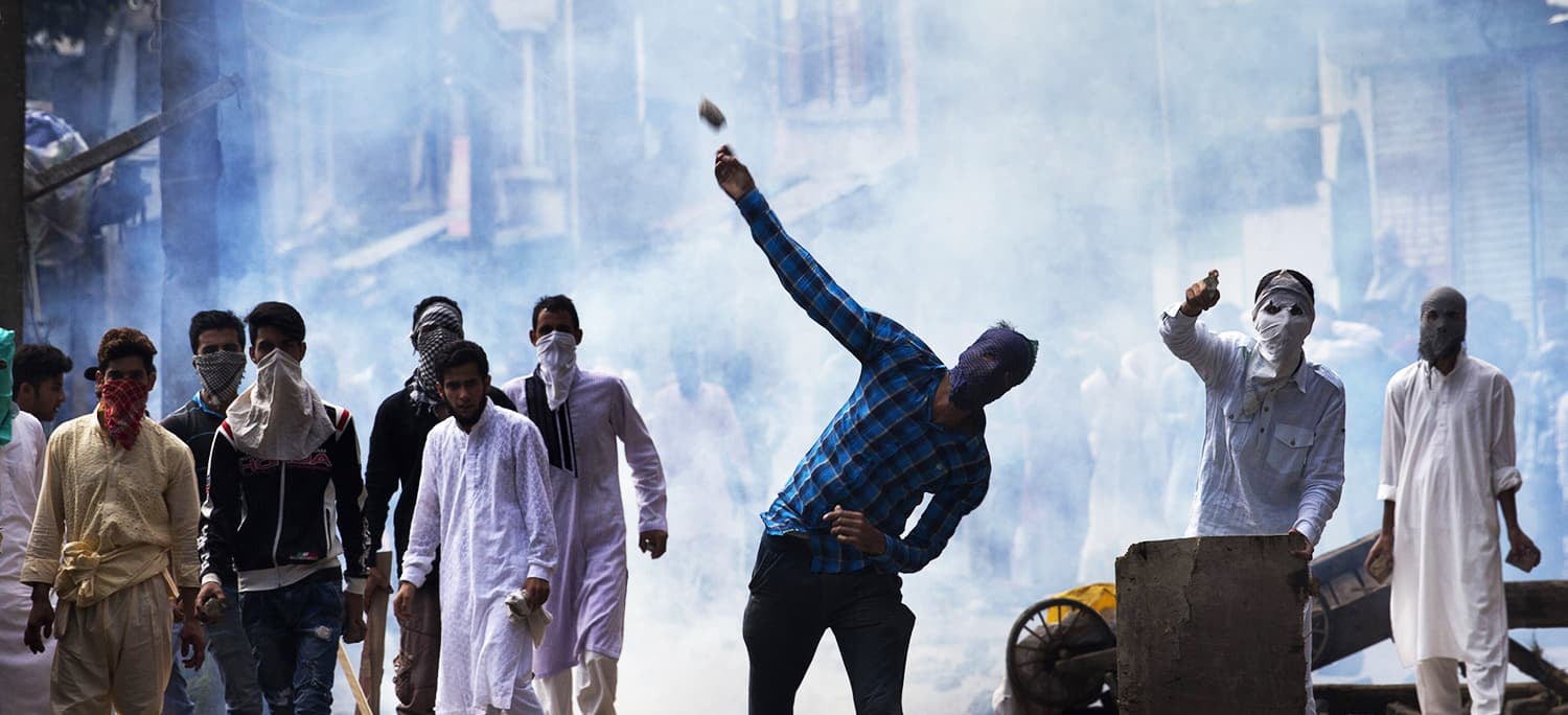 A Kashmiri throws a rock at Indian security personnel during a protest after Eidul Azha prayers in Srinagar, Sept 13, 2016. — AP/File