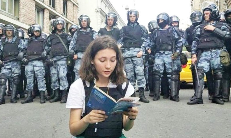 نوجوان لڑکی نے اطمینان سے آئین کو پڑھنا شروع کیا&mdash;فوٹو: VERA OLEINIKOVA