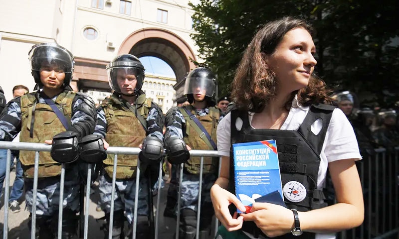 پولیس والوں کے سامنے آئین کی کتاب پڑھنے والی لڑکی کی تصاویر وائرل ہوگئیں&mdash;فوٹو: اے پی