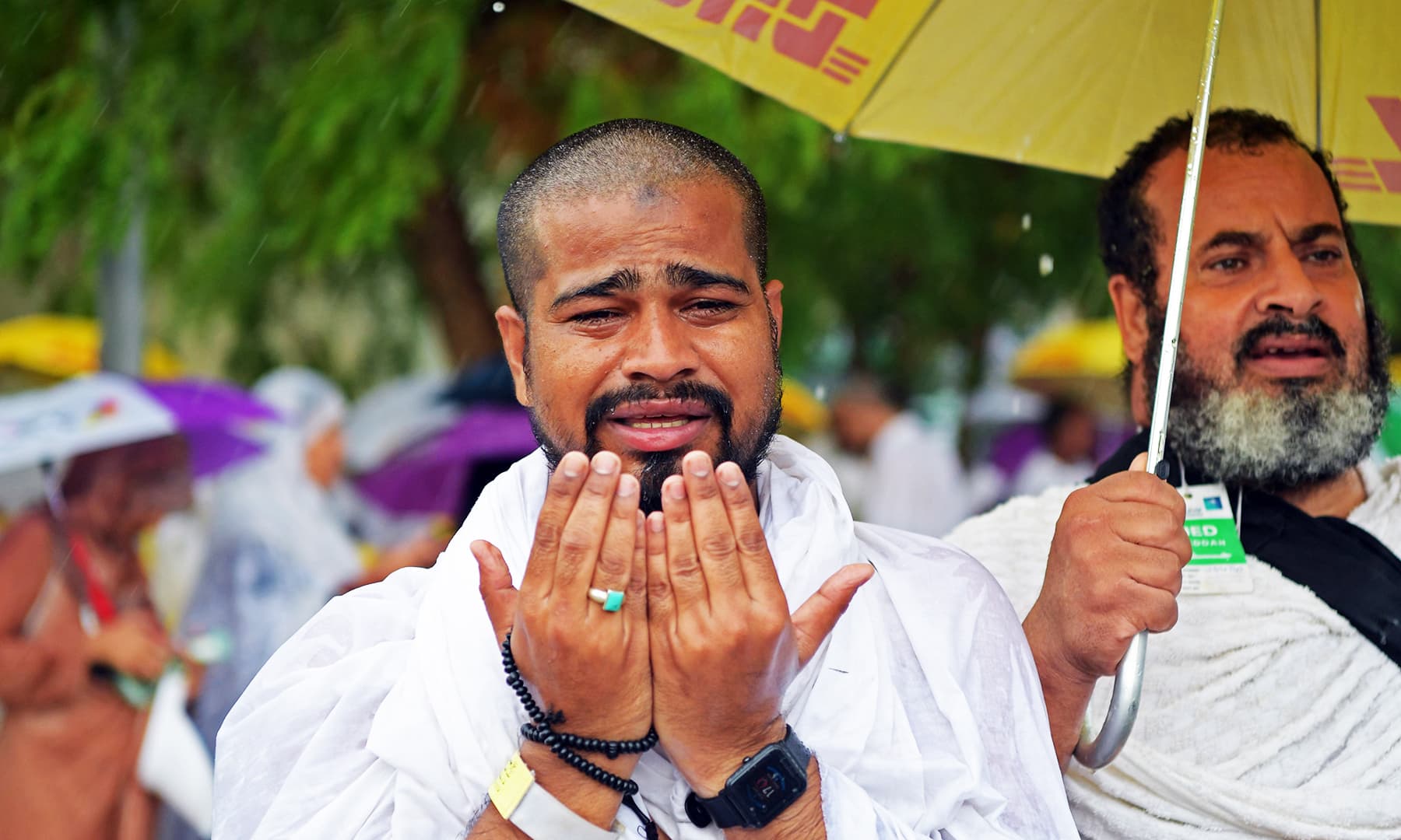 A pilgrim prays under the rain near Mount Arafat, also known as Jabal al-Rahma (Mount of Mercy). — AFP