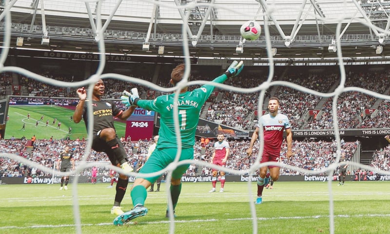 LONDON: Raheem Sterling (L) scores his third goal for Manchester City against West Ham United during their Premier League match at the London Stadium on Saturday.—Reuters