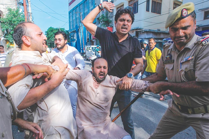 JAMMU: Police taking an activist of Jammu and Kashmir Youth Congress into custody during a protest against the Indian government on Saturday.—AFP