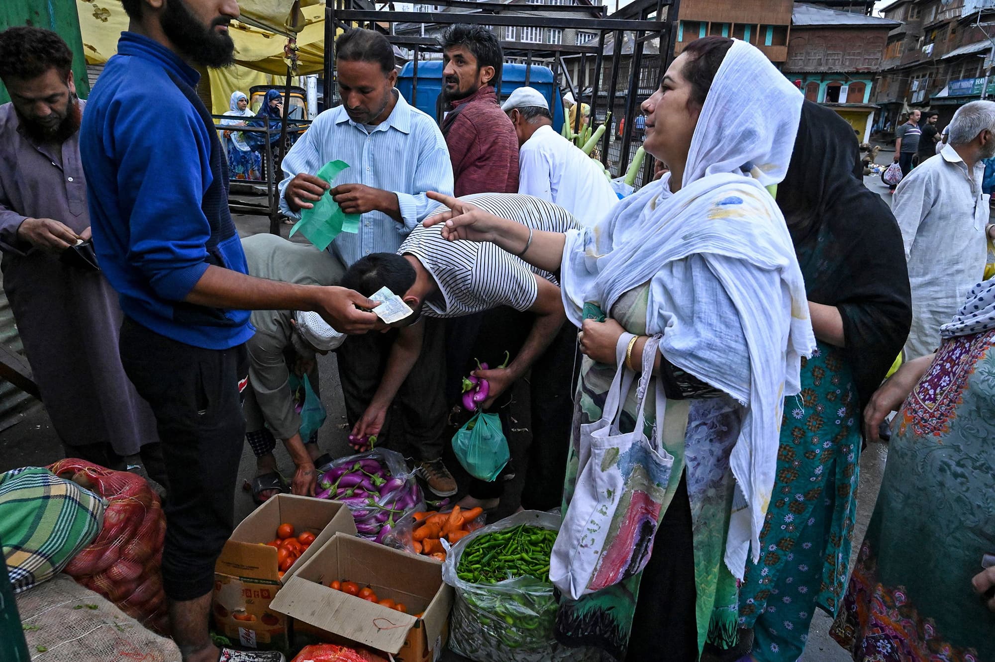 Kashmiris purchase food and vegetables during a lockdown in Srinagar. ─ AFP