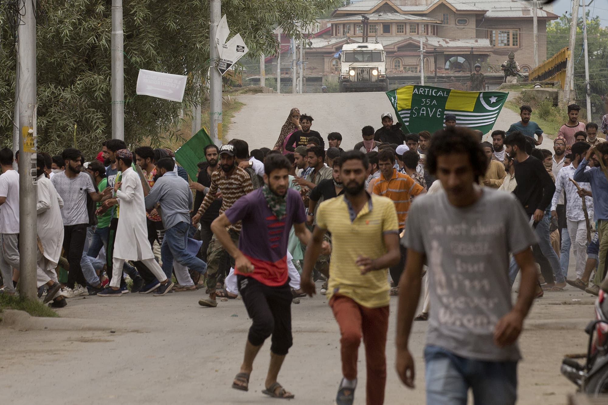 Kashmiris run for cover as Indian policemen chase them during a protest march in Srinagar. ─ AP