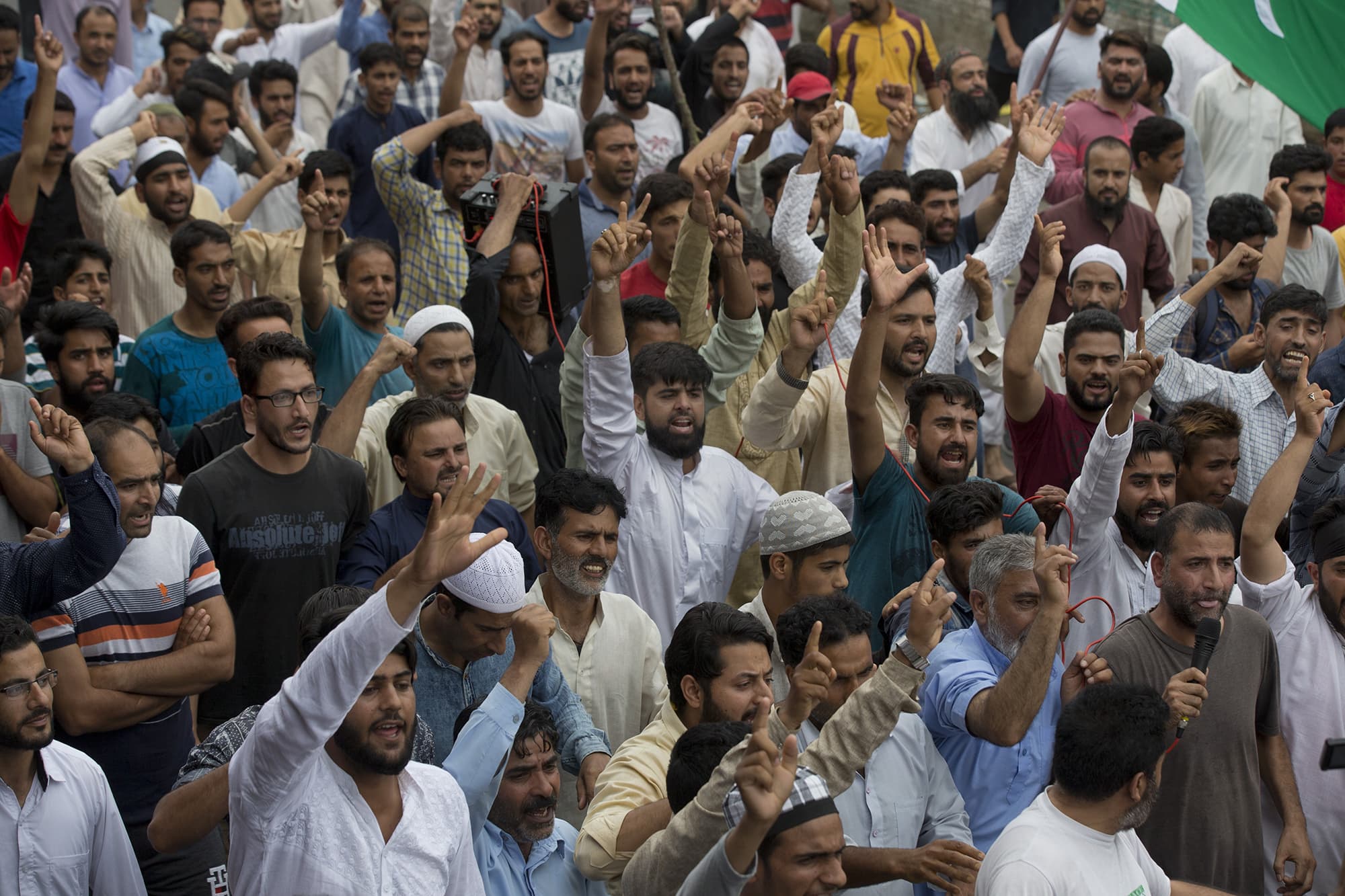 Kashmiris shout slogans as Indian policemen fire teargas and live ammunition in the air to stop a protest march in Srinagar. ─ AP