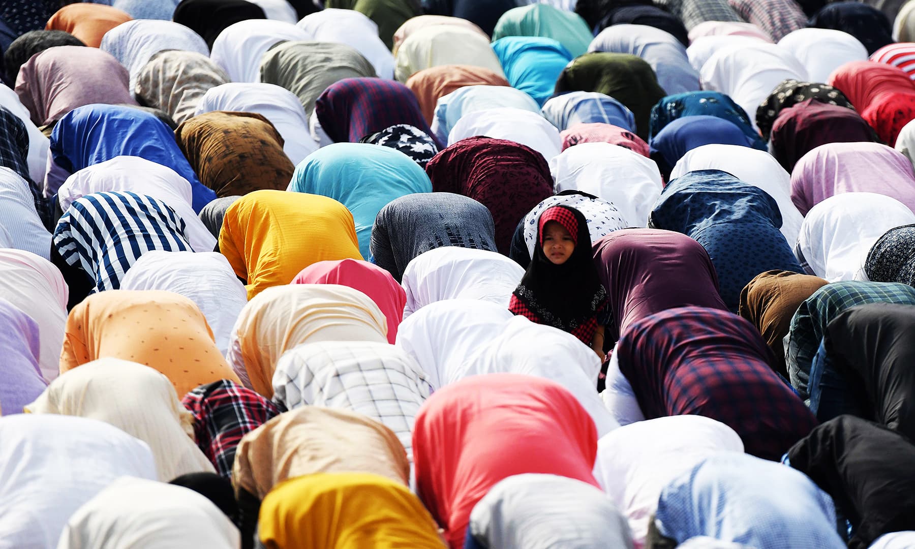 A child looks on as people offer Eidul Azha prayers in Chennai, India. &mdash; AFP