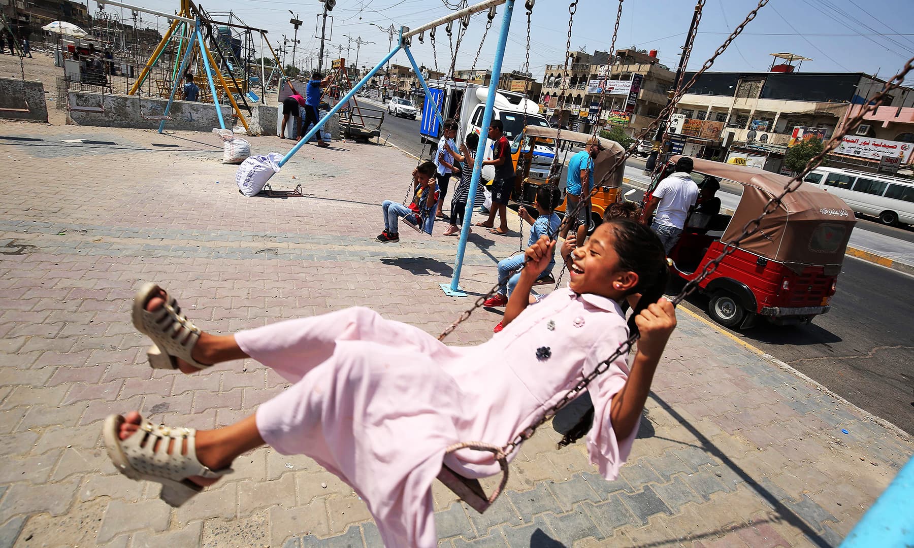 A girl rides on a swing in the Iraqi capital Baghdad's eastern suburb of Sadr City. &mdash; AFP