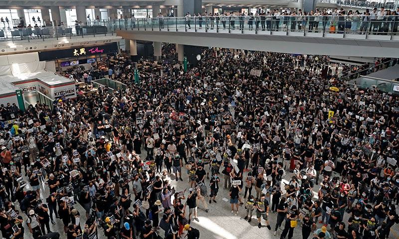 مظاہرین نے پولیس کے خلاف پلے کارڈ اٹھائے رکھے تھے&mdash;فوٹو: رائٹرز