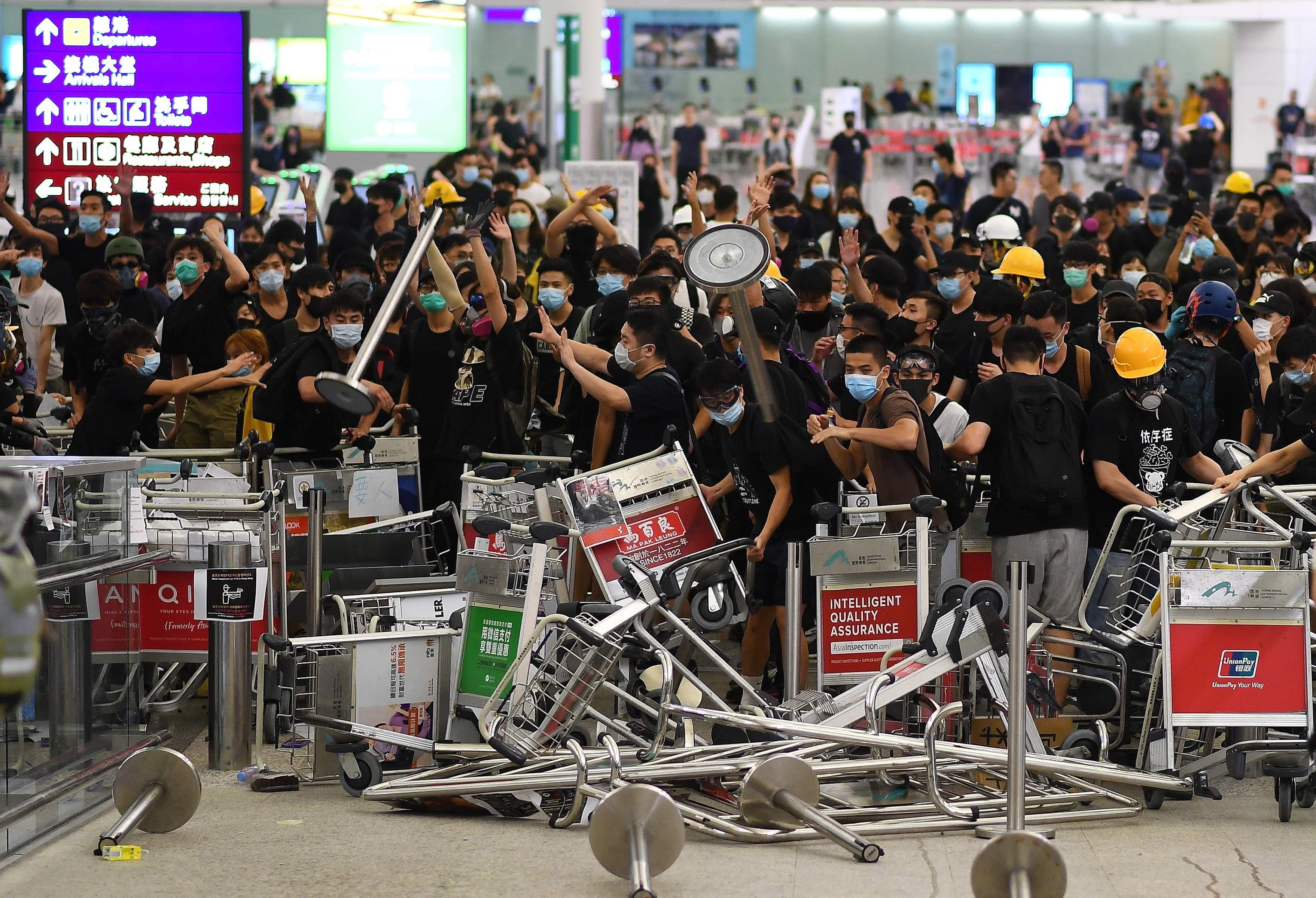 Pro-democracy protestors block the entrance to the airport terminals after a scuffle with police at Hong Kong's international airport on Tuesday. — AFP