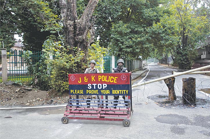 SRINAGAR: Indian paramilitary soldiers man a temporary checkpoint on a deserted road on Thursday.—AP