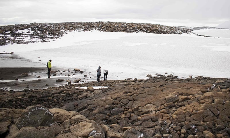 People look at the snow at the old glacier after a monument was unveiled at site of Okjokull, Iceland's first glacier lost to climate change in the west of Iceland on August 18. — AFP