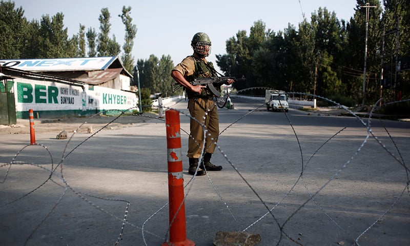 An Indian security personnel stands guard on a deserted road in Srinagar in occupied Kashmir on August 23. — Reuters