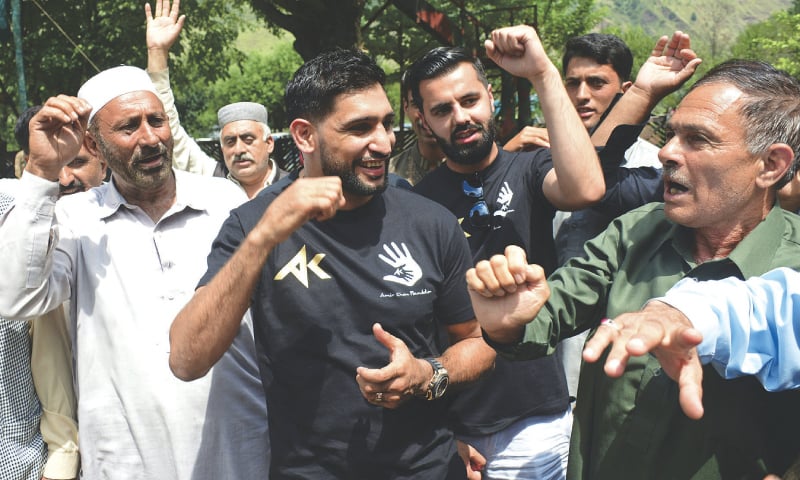 MUZAFFARABAD: Boxer Amir Khan meets Kashmiris living along the Line of Control in Chakoti area on Tuesday. — AP