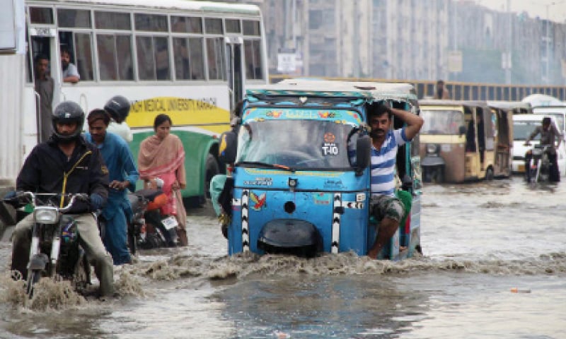 Vehicles drive through rainwater in the Nagan Chowrangi area on Wednesday. &mdash; Online