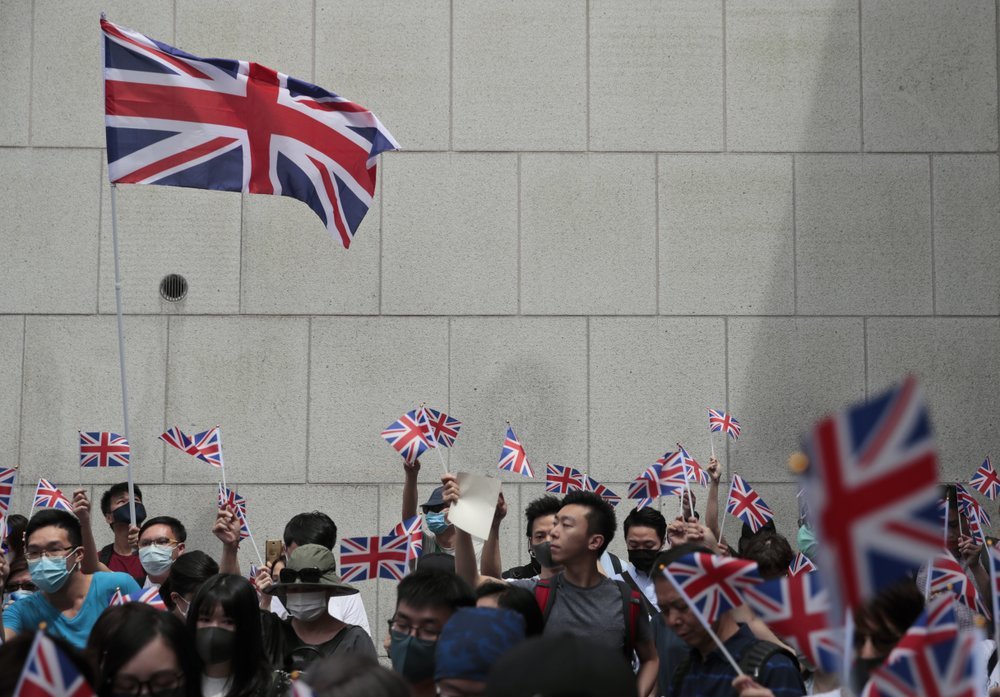 Protestors wave British flags and participate in a peaceful demonstration outside the British Consulate in Hong Kong on Sunday. ─ AP