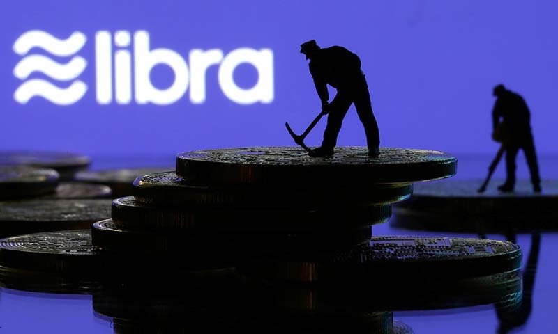 Small toy figures are seen on representations of virtual currency in front of the Libra logo in this illustration picture on June 21. &mdash; Reuters