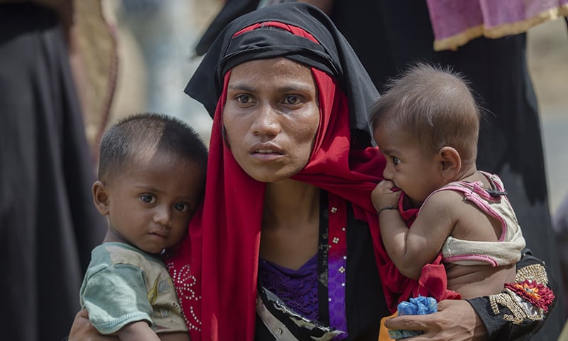 In this Oct 22, 2017, file photo, a Rohingya Muslim woman, Rukaya Begum, who crossed over from Myanmar into Bangladesh, holds her son Mahbubur Rehman, left and her daughter Rehana Bibi, after the government moved them to newly allocated refugee camp areas, near Kutupalong, Bangladesh. — AP/File