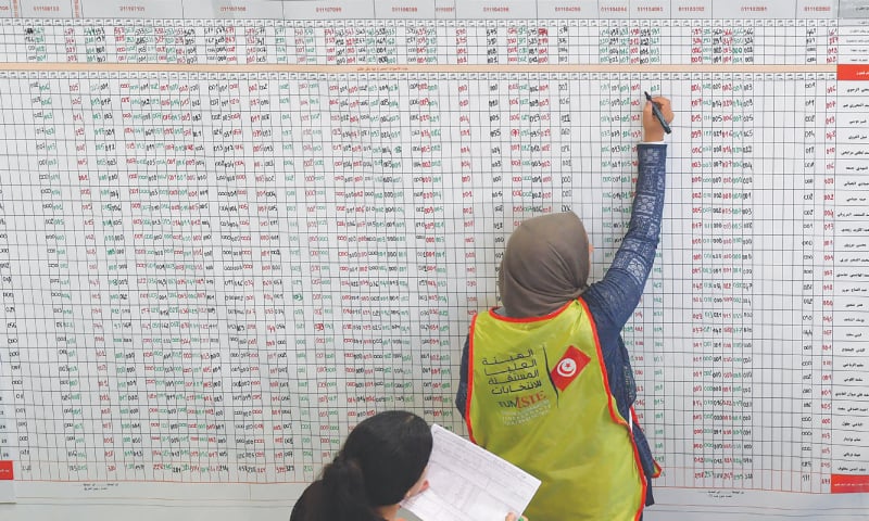 ARIANA: Staffers of Tunisia’s election commission tally votes as they prepare the results of the presidential vote on Monday.—AFP