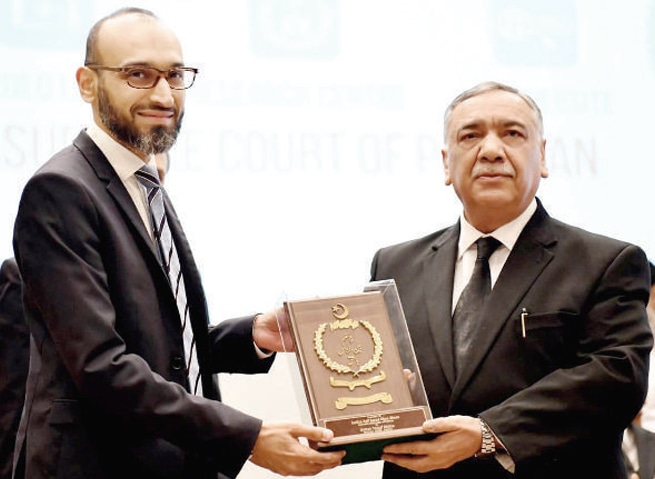 Chief Justice of Pakistan Asif Saeed Khosa presents a shield to Nadra Chairman Usman Yousuf Mobeen. &mdash; White Star