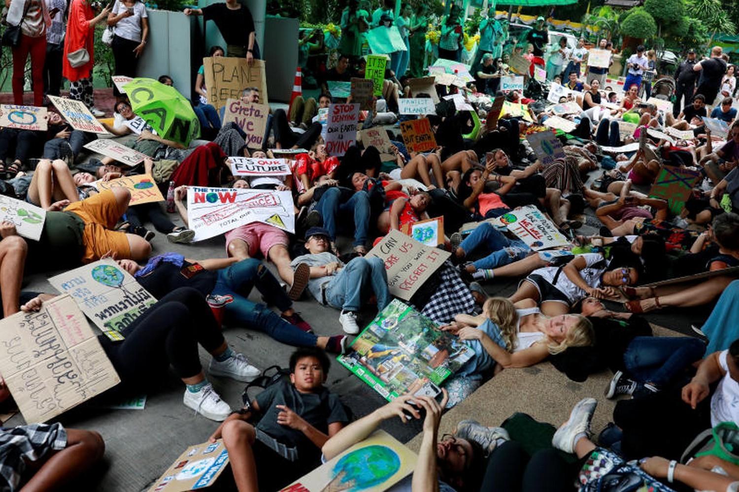 Young environmental activists play dead as they participate in a Global Climate Strike at the Ministry of Natural Resources and Environment office in Bangkok on Friday. ─ Reuters