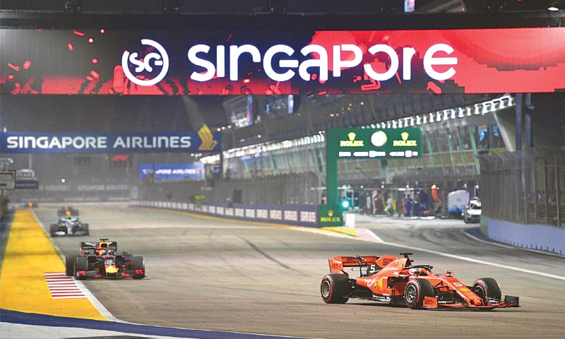 Ferrari’s Sebastian Vettel (R) takes part in the Singapore F1 Grand Prix at the Marina Bay Street Circuit on Sunday.—AFP