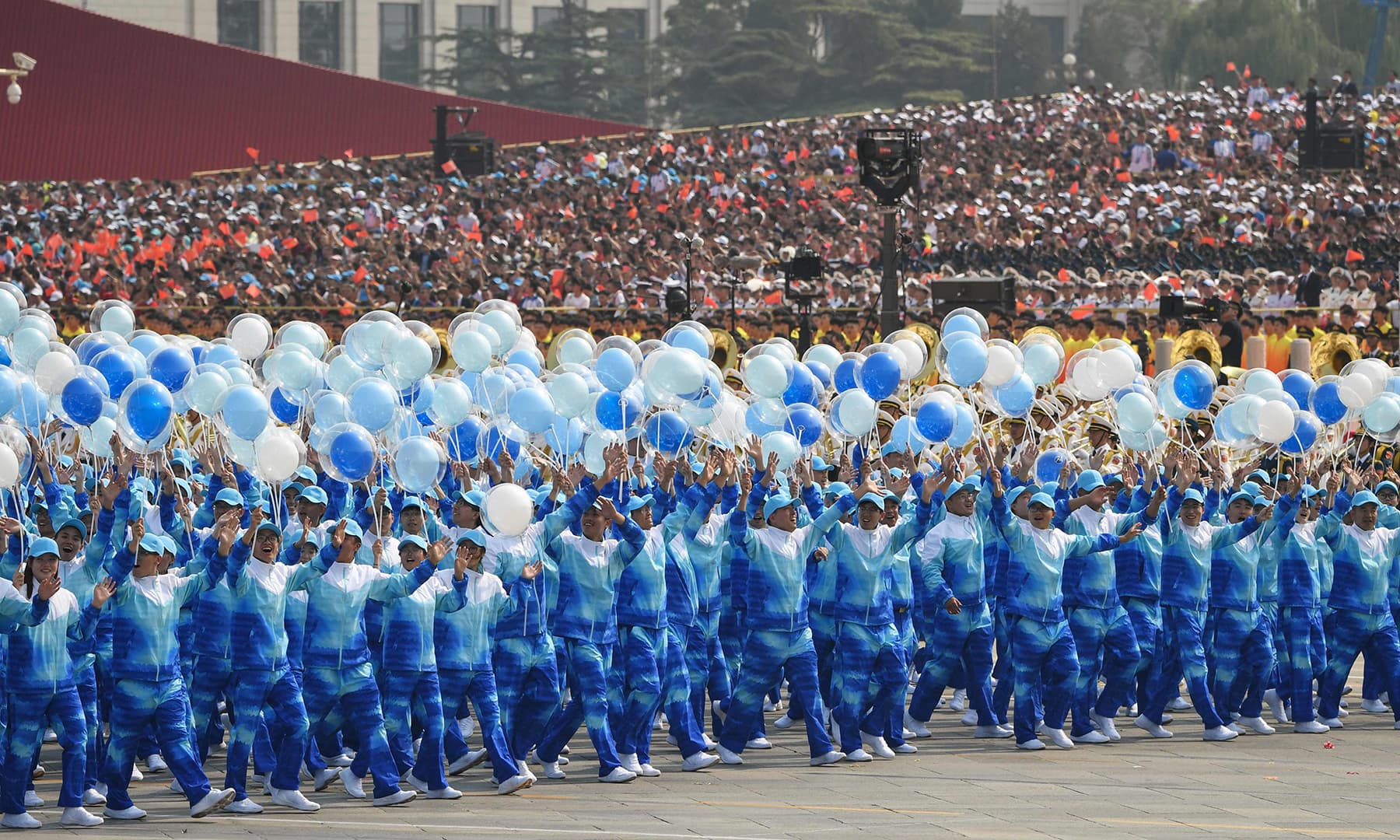 People take part in the National Day parade in Tiananmen Square in Beijing. — AFP