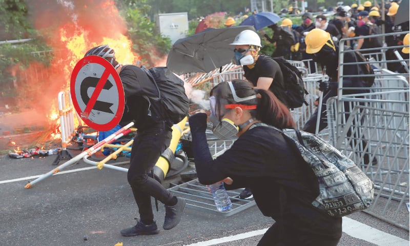 Hong Kong: An anti-government protester shelters himself with a traffic sign during clashes with police on Tuesday. Strife-torn Hong Kong marked the 70th anniversary of communist China&rsquo;s founding with a defiant &ldquo;day of grief&rdquo; protests.&mdash;Reuters