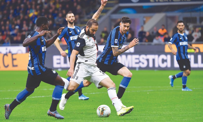MILAN: Juventus’ Gonzalo Higuain (C) shoots to score during the Serie A match against Inter Milan at the San Siro Stadium.—AFP MILAN: Juventus’ Gonzalo Higuain (C) shoots to score during the Serie A match against Inter Milan at the San Siro Stadium.—AFP