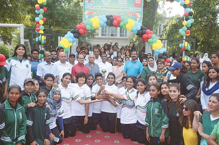 LAHORE: Students and teachers of Lahore College for Women University along with POA officials and sportspersons pose for a group photo with the 33rd National Games torch on Thursday.—Online